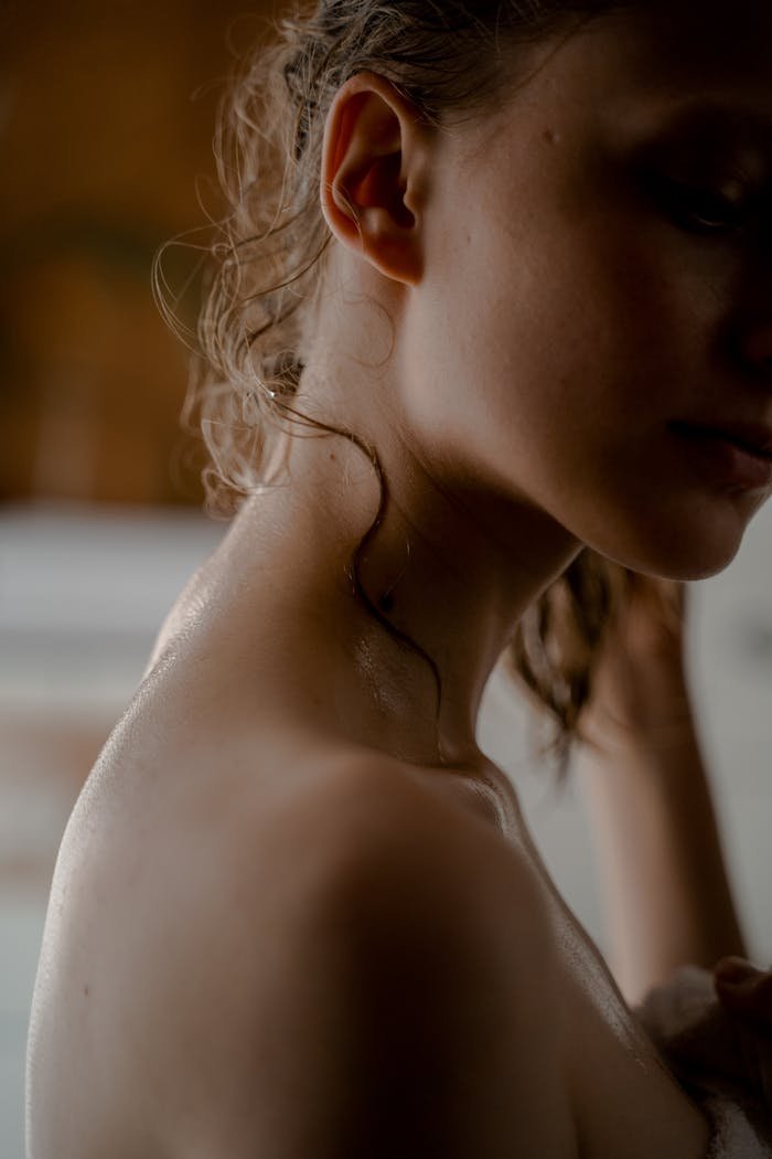 Artistic close-up of a woman's wet shoulder and neck, highlighting elegance and beauty.
