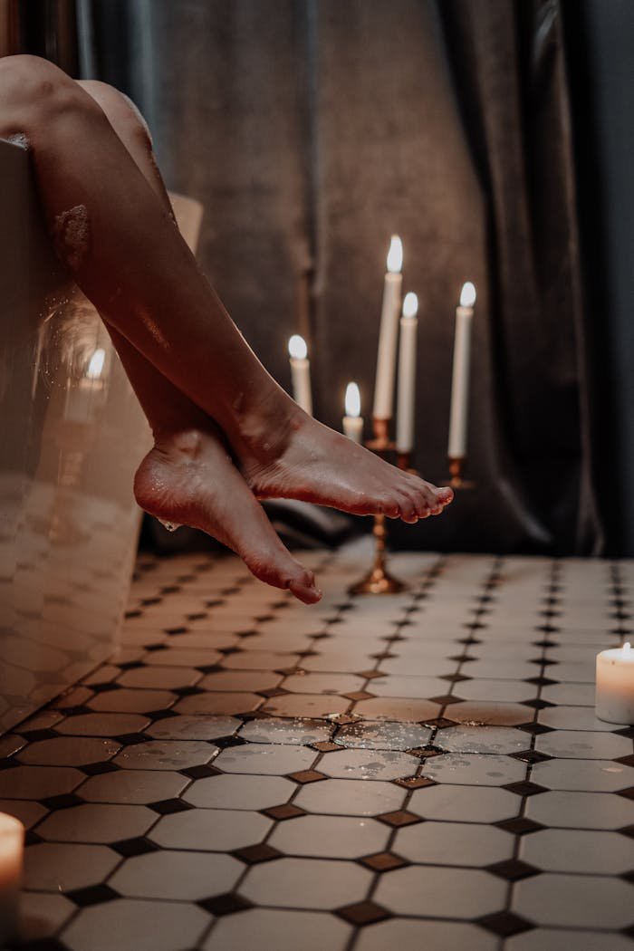 Relaxing bathtub scene with candles and ambient lighting creates a serene mood.